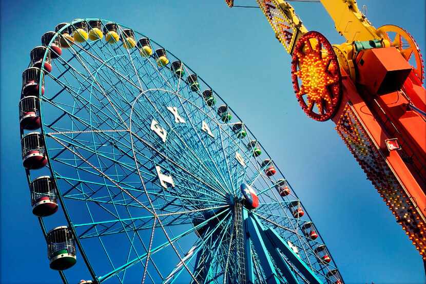 Fairgoers ride the Texas Star ferris wheel during the State Fair of Texas at Fair Park in...