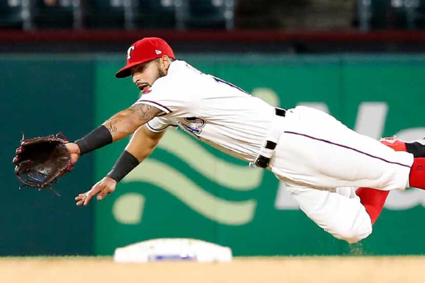 Texas Rangers second baseman Rougned Odor (12) dives for the ball during the 7th inning...