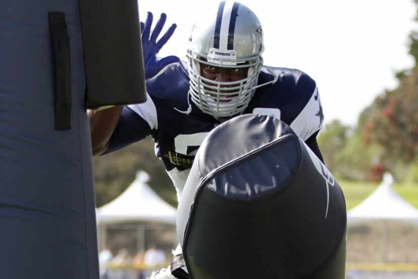 Dallas Cowboys defensive end DeMarcus Ware (94) leaps to knock over a dummy in a drill...