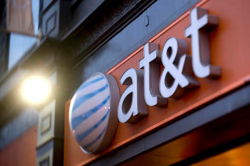 AT&T Inc. signage hangs outside a store in the Chinatown neighborhood in this photo taken...