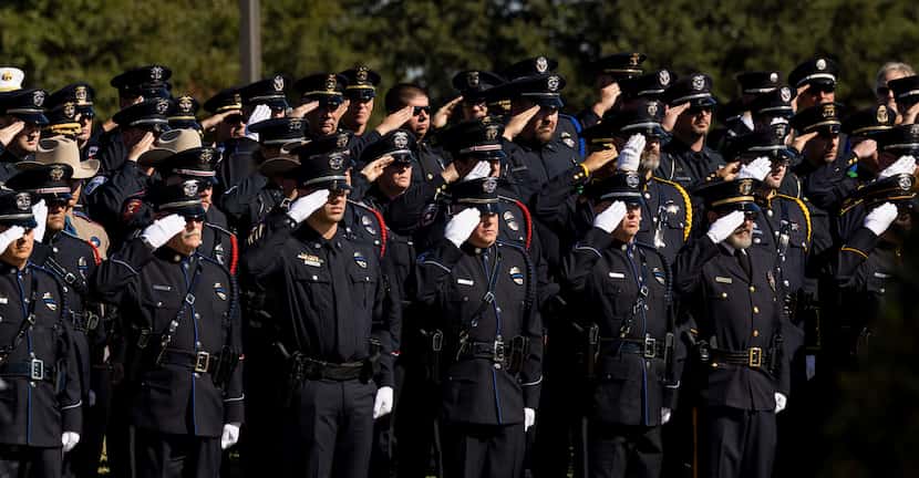 Officers salute during the funeral service for Carrollton police Officer Steve Nothem on...