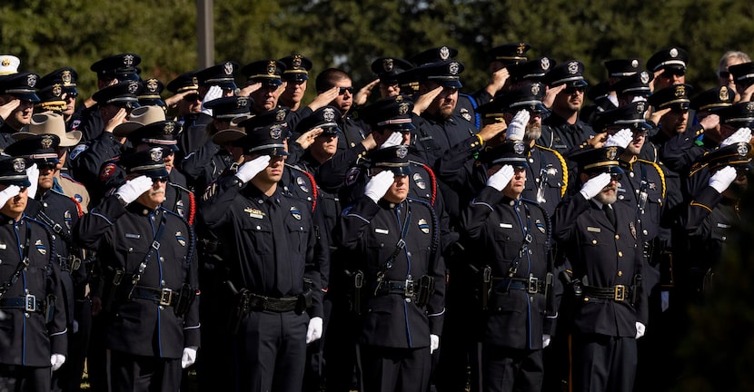 Officers salute during the funeral service for Carrollton police Officer Steve Nothem on...