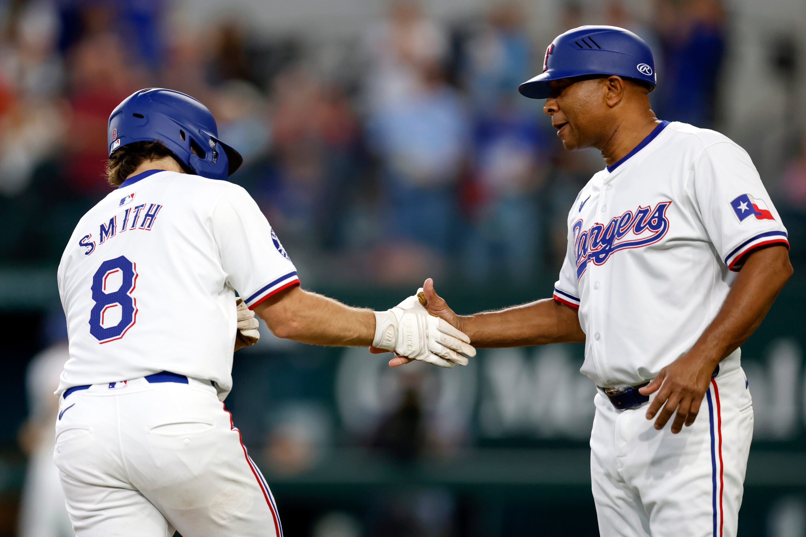 Texas Rangers third baseman Josh Smith (8) high-fives third base coach Tony Beasley after a...