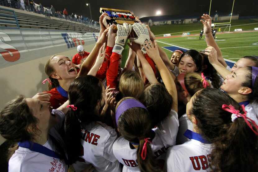 File photo, 2018: Ursuline players stretch to reach the state championship trophy they were...