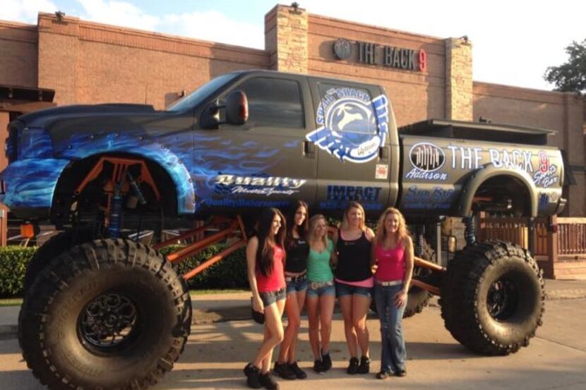 The women standing in front of the Back 9's monster truck would likely need a small ladder...