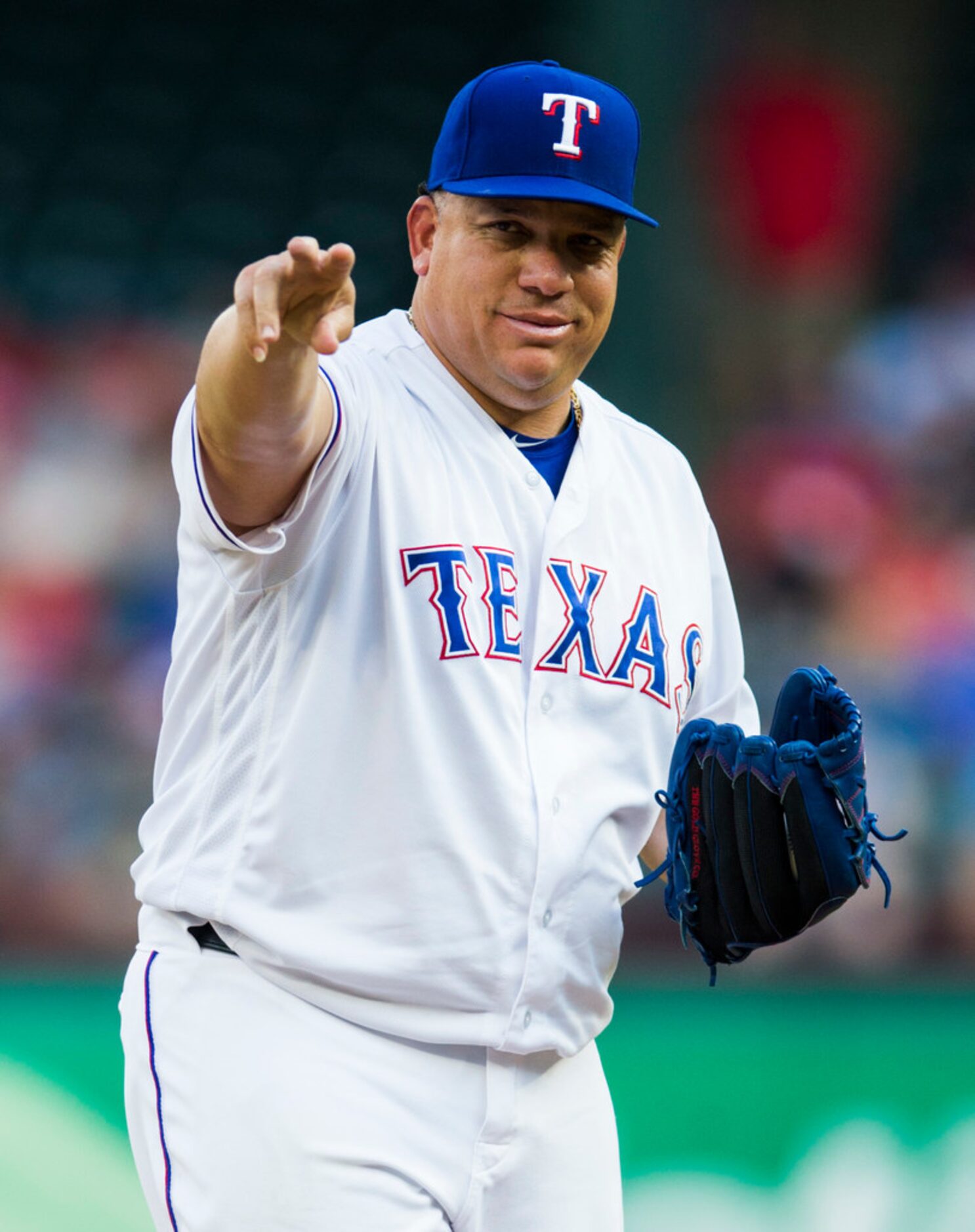 Texas Rangers starting pitcher Bartolo Colon (40) points to the Oakland Athletics dugout...