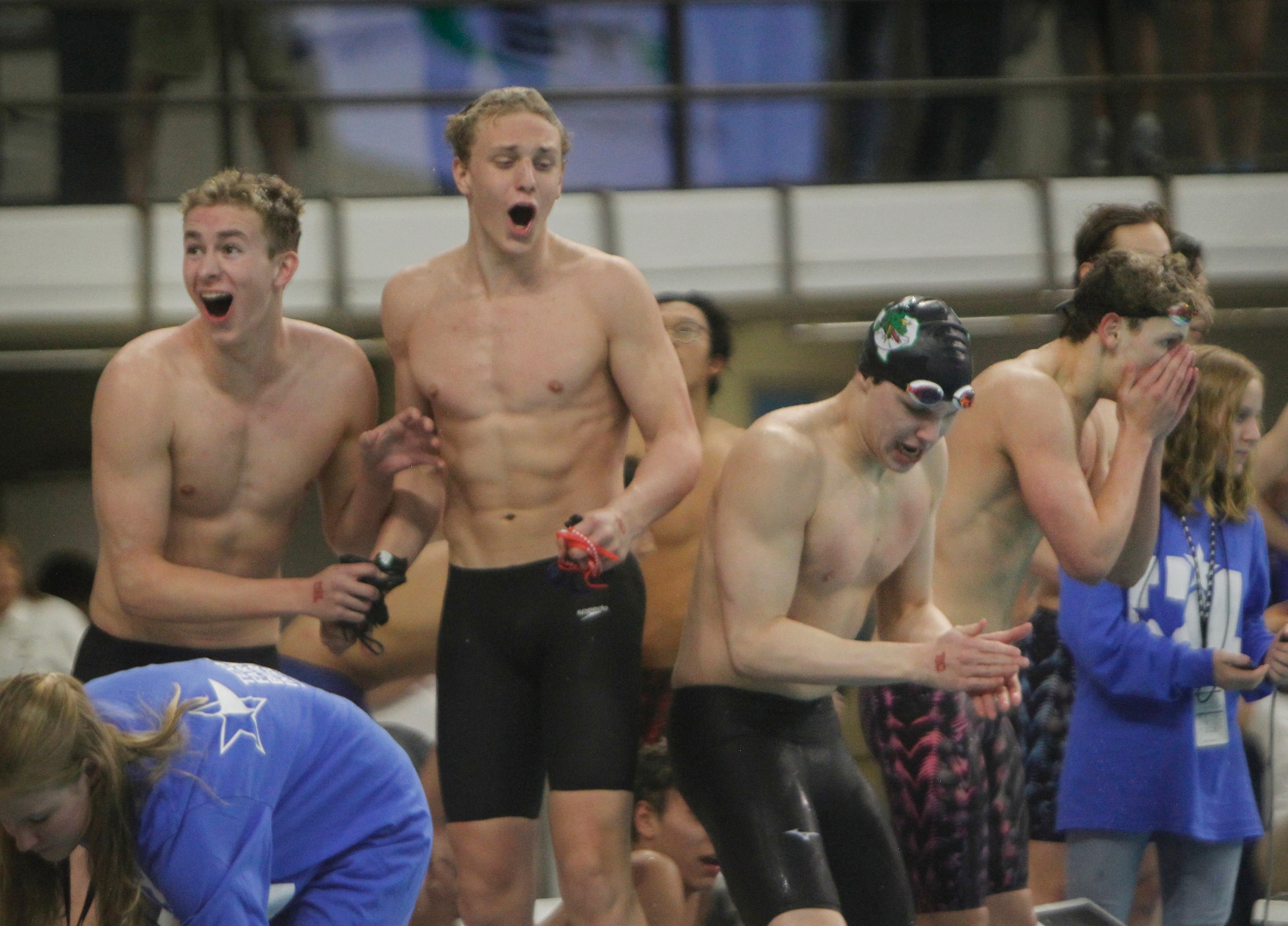 Members of the Southlake Carroll boys swim relay team react when announced they narrowly won...