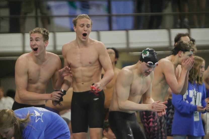 Members of the Southlake Carroll boys swim relay team react when announced they narrowly won...