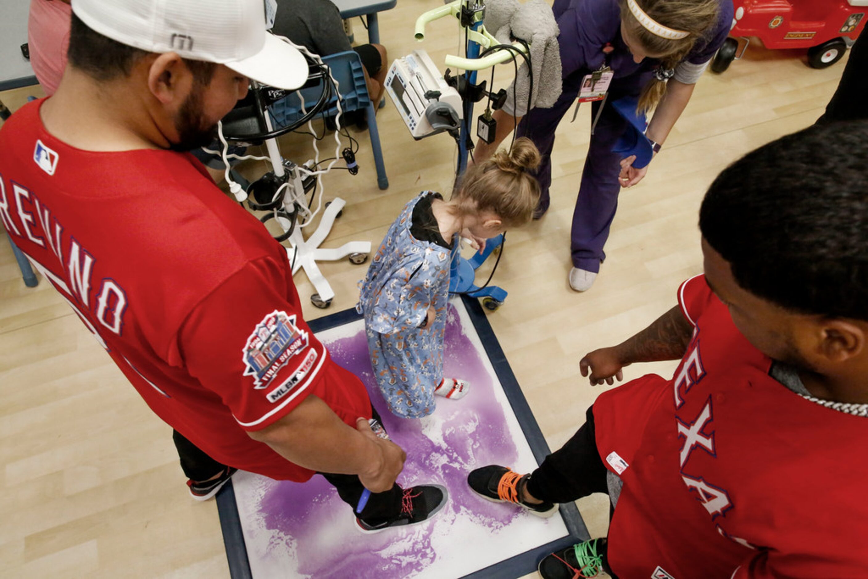 Texas Rangers catcher Jose Trevino,left and  outfielder Willie Calhoun play with 5-year-old...