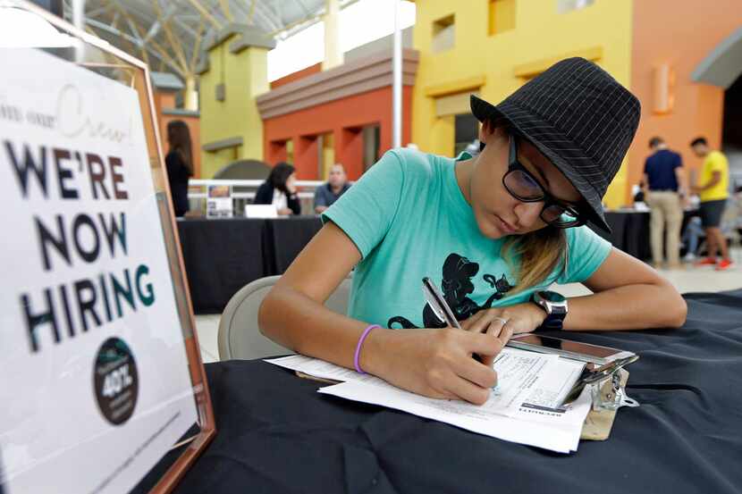FILE - In this Oct. 4, 2017 file photo, job seeker Alejandra Bastidas fills out an...