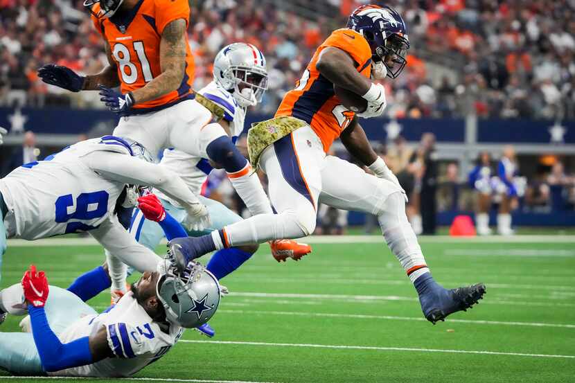 Denver Broncos running back Melvin Gordon (25) gets past Dallas Cowboys defensive back...