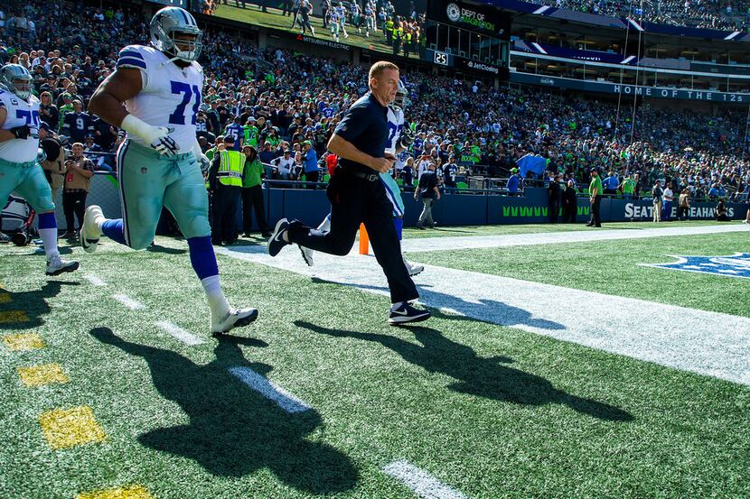 Dallas Cowboys head coach Jason Garrett leads his team onto the field with offensive tackle...