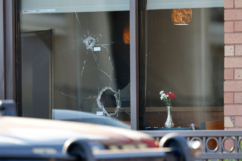 Ventanas rotas por impactos de bala se pueden ver en el Chick-fil-A de Las Colinas luego de...