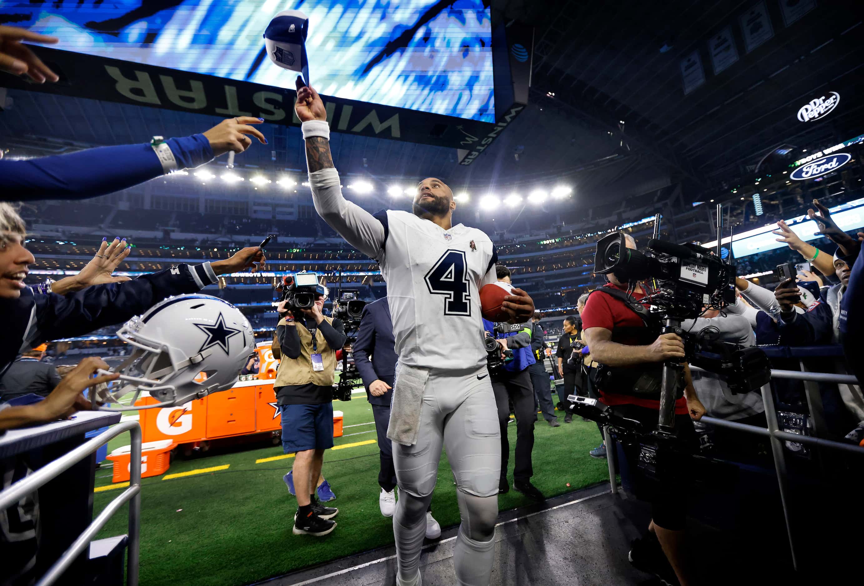 Dallas Cowboys quarterback Dak Prescott (4) tosses his hat to fans as he runs off the field...