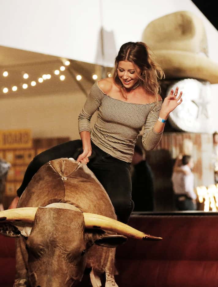 Mary Lauren Mandina ride the mechanical bull during the Cattle Baron's Ball at Gilley's...