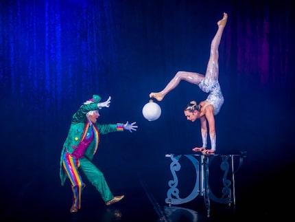 An acrobatic display from a Cirque show, a woman standing on her hands holds a Christmas...