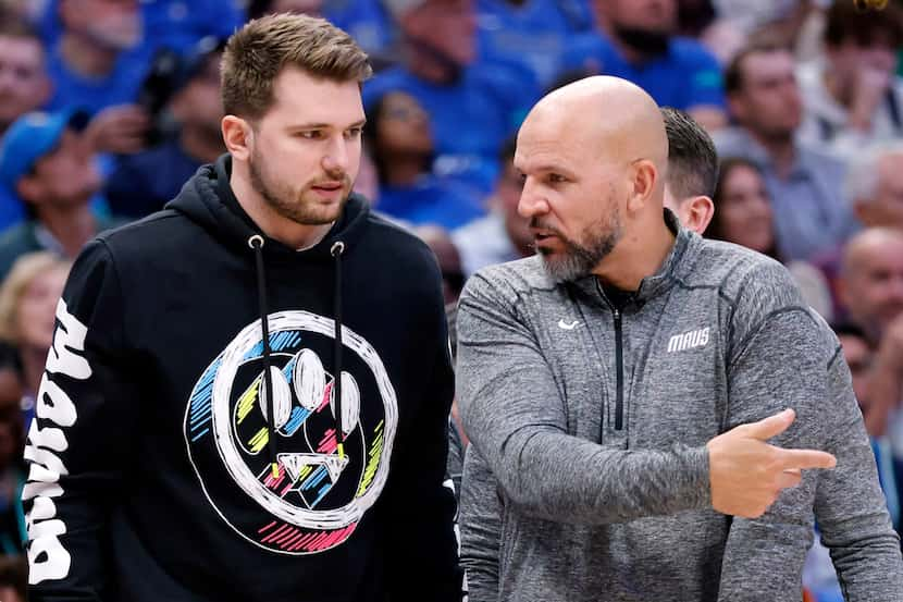 Dallas Mavericks guard Luka Doncic (left) listens to an explanation from head coach Jason...