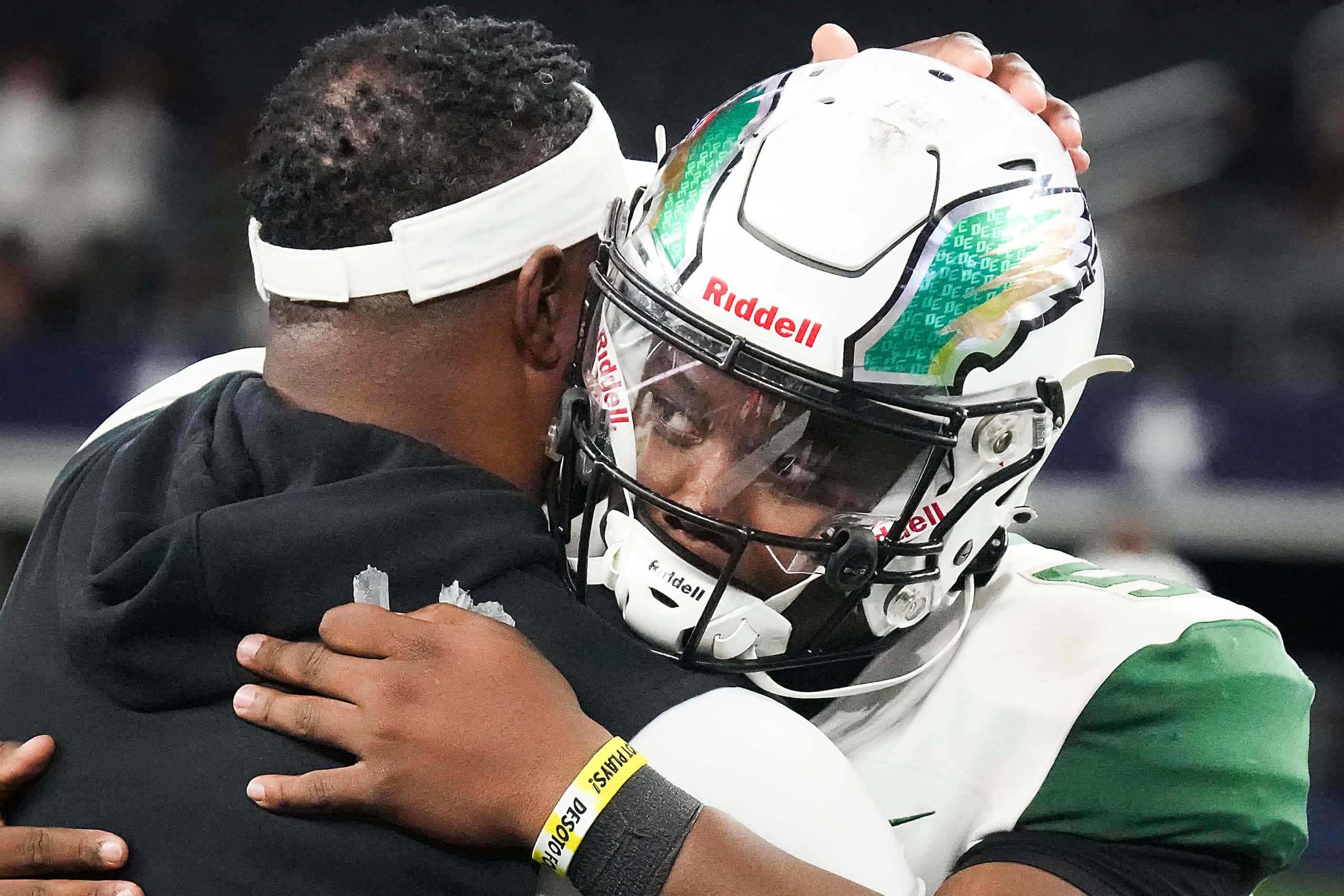 DeSoto head coach Claude Mathis hugs quarterback DJ Bailey in the final minute of a victory...