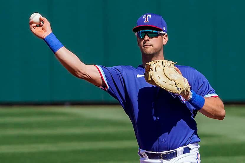 Texas Rangers infielder Nate Lowe makes a throw to get San Francisco Giants third basman...