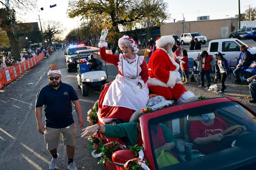 In this 2018 file photo, Mrs. Claus and Santa Claus wave to families while tossing candy as...