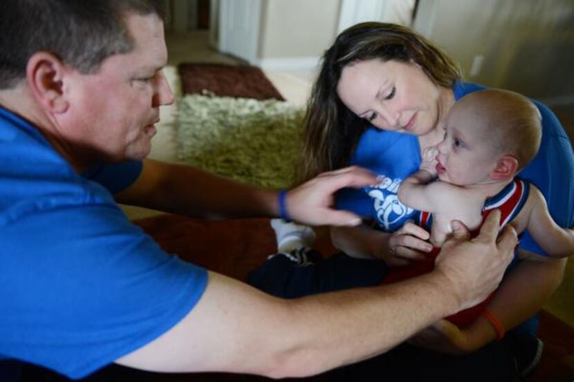 
Rockwall ISD teachers Jason and Jamie Foster rub lotion on their son, Jamison, who was born...