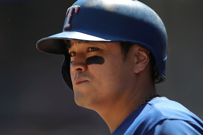 Texas Rangers' Shin-Soo Choo is seen in the dugout during the seventh inning of a baseball...