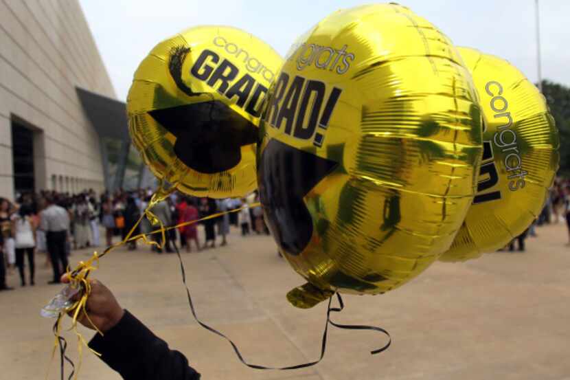 Wind whips a bouquet of congratulatory balloons after Plano East Senior High School's...