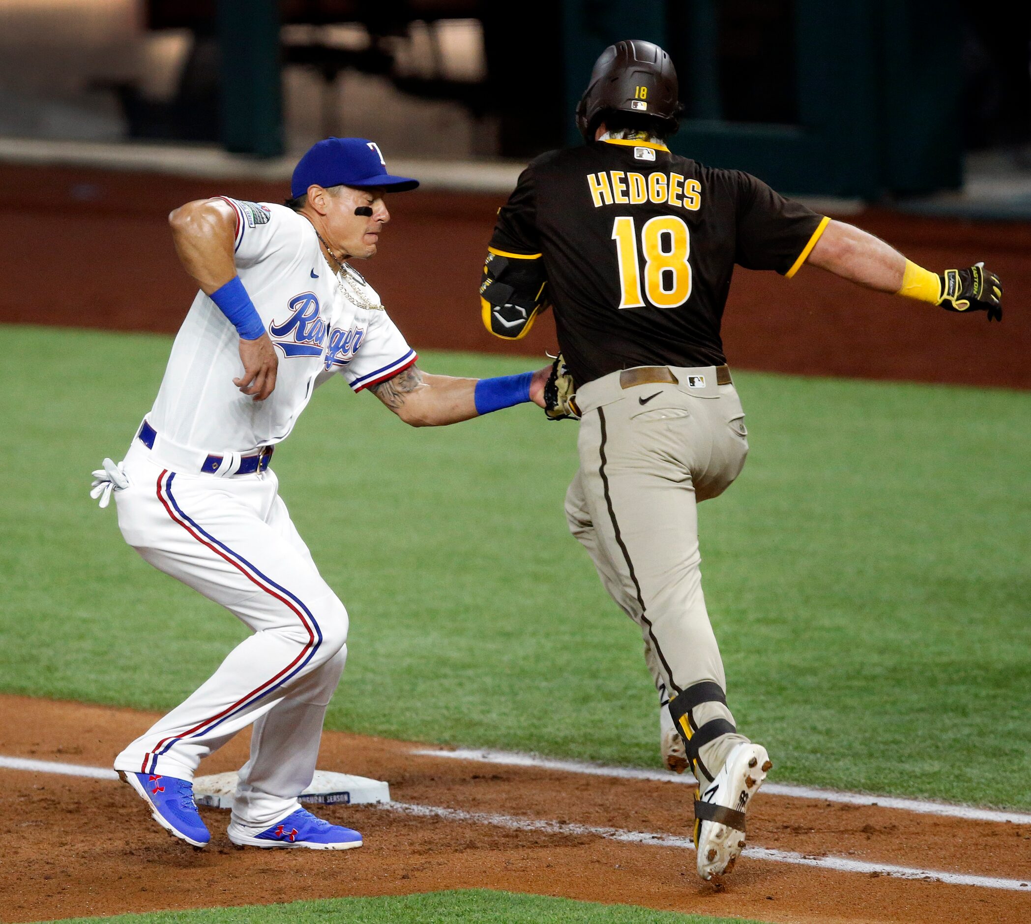 Texas Rangers first baseman Derek Dietrich (32) tags out San Diego Padres Austin Hedges (18)...