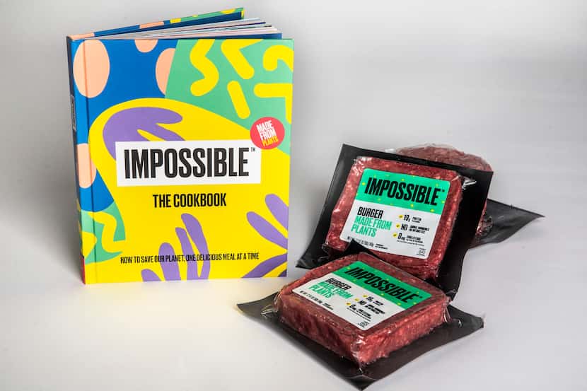 “IMPOSSIBLE: The Cookbook” is photographed alongside packets of Impossible meatless ground...