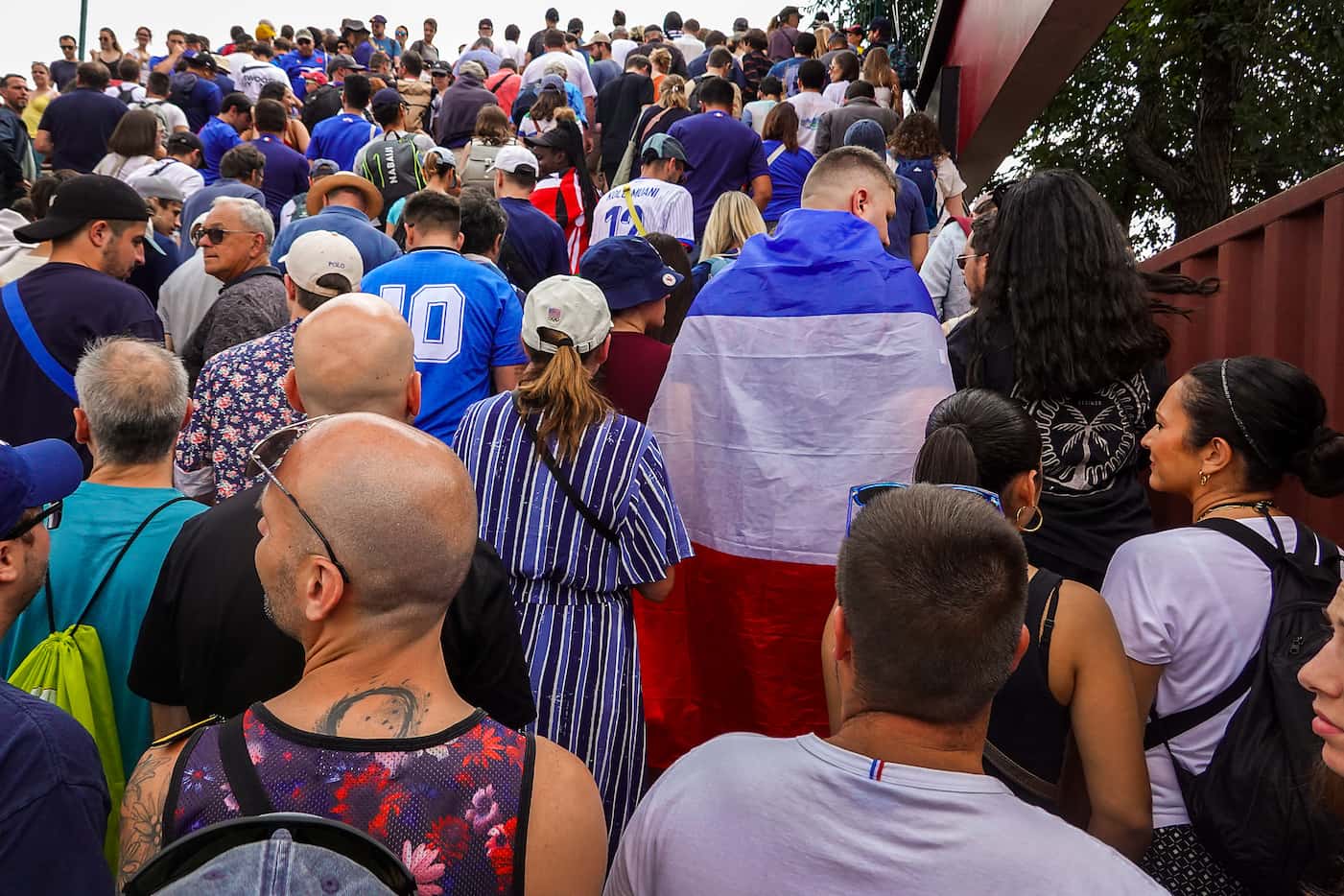 Fans wait in a long line to enter the Stade de France for the opening session of rugby...