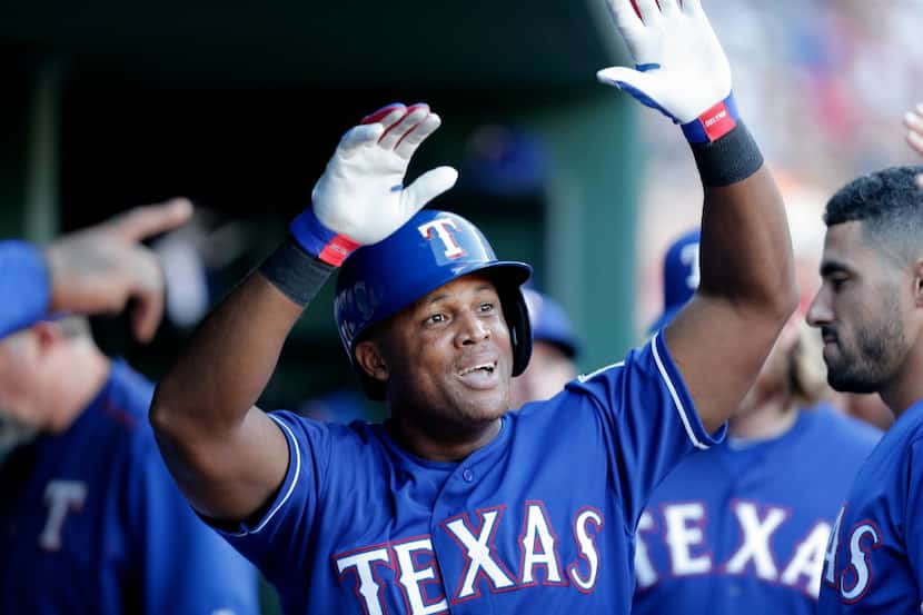 Texas Rangers' Adrian Beltre (29) is congratulated by teammates after scoring on a double by...