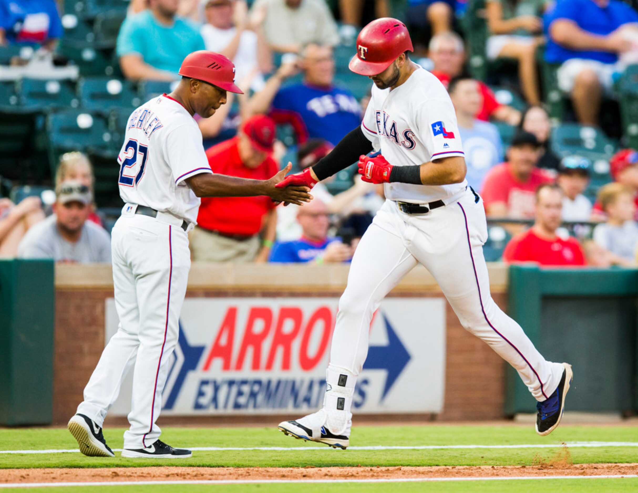 Texas Rangers out fielder Joey Gallo (13) gets a high-five from third base coach Tony...