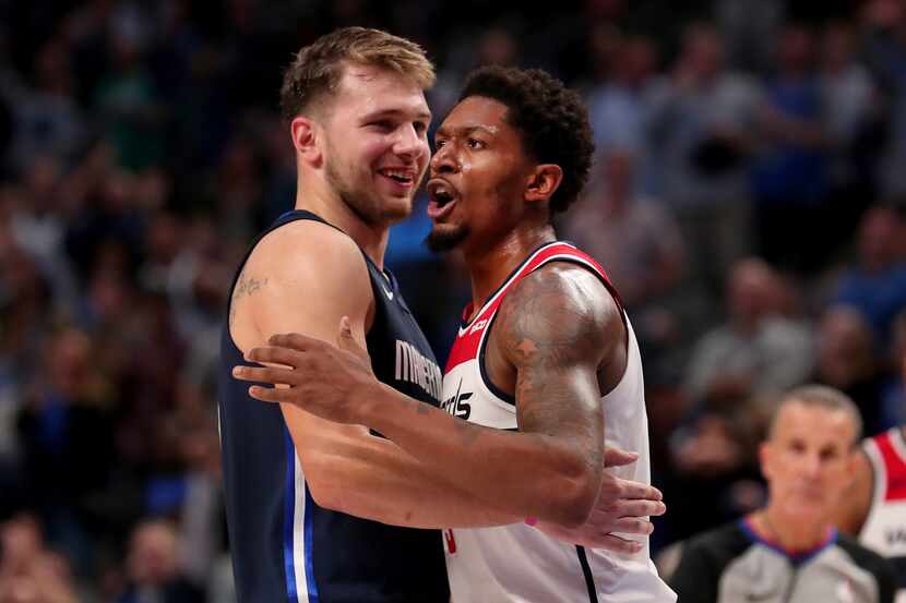 DALLAS, TEXAS - OCTOBER 23: Bradley Beal #3 of the Washington Wizards hugs Luka Doncic #77...