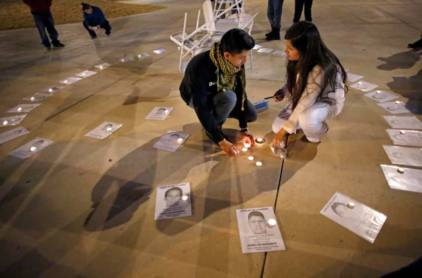 
Jaime Santana (left) and Rosalia Salazar placed candles on pictures of the victims from...
