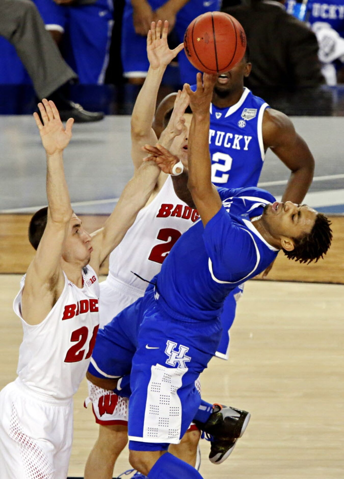 Wisconsin Badgers guard Josh Gasser (21) defends Kentucky Wildcats guard/forward James Young...