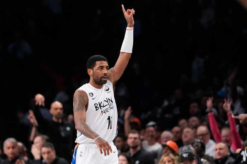 Brooklyn Nets guard Kyrie Irving reats after scoring a three-point basket during the second...