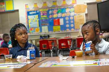 Azaria Ross, 6 (left), and Money Lucky, 6 (right), eat breakfast at Martin Luther King Jr....