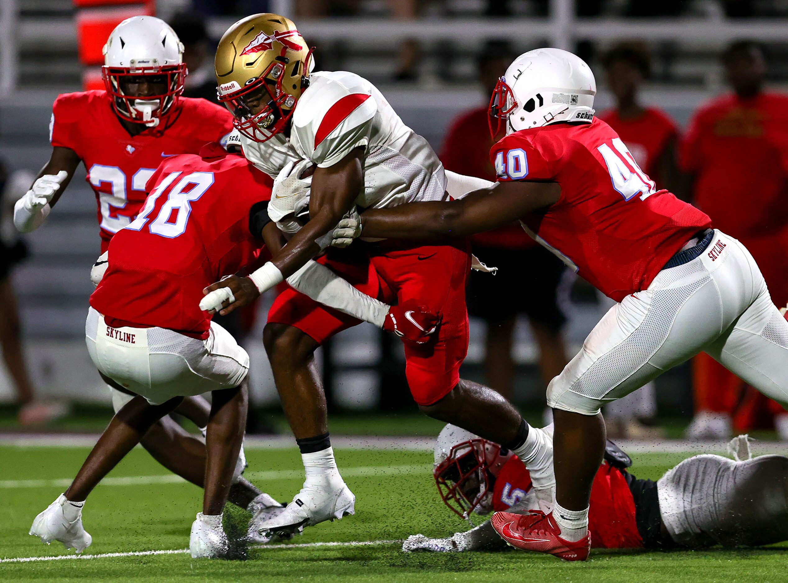 South Grand Prairie running back AJ Newberry (C) tries to break tackles against Skyline...