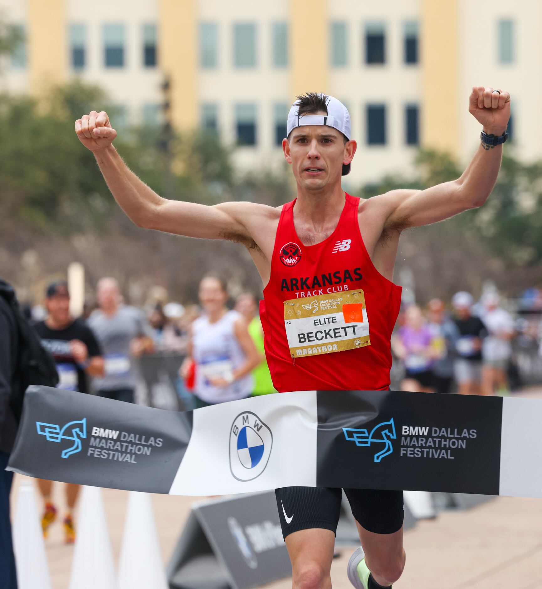 Cameron Beckett pumps his fists in the air as he crosses the finish line in first place at...