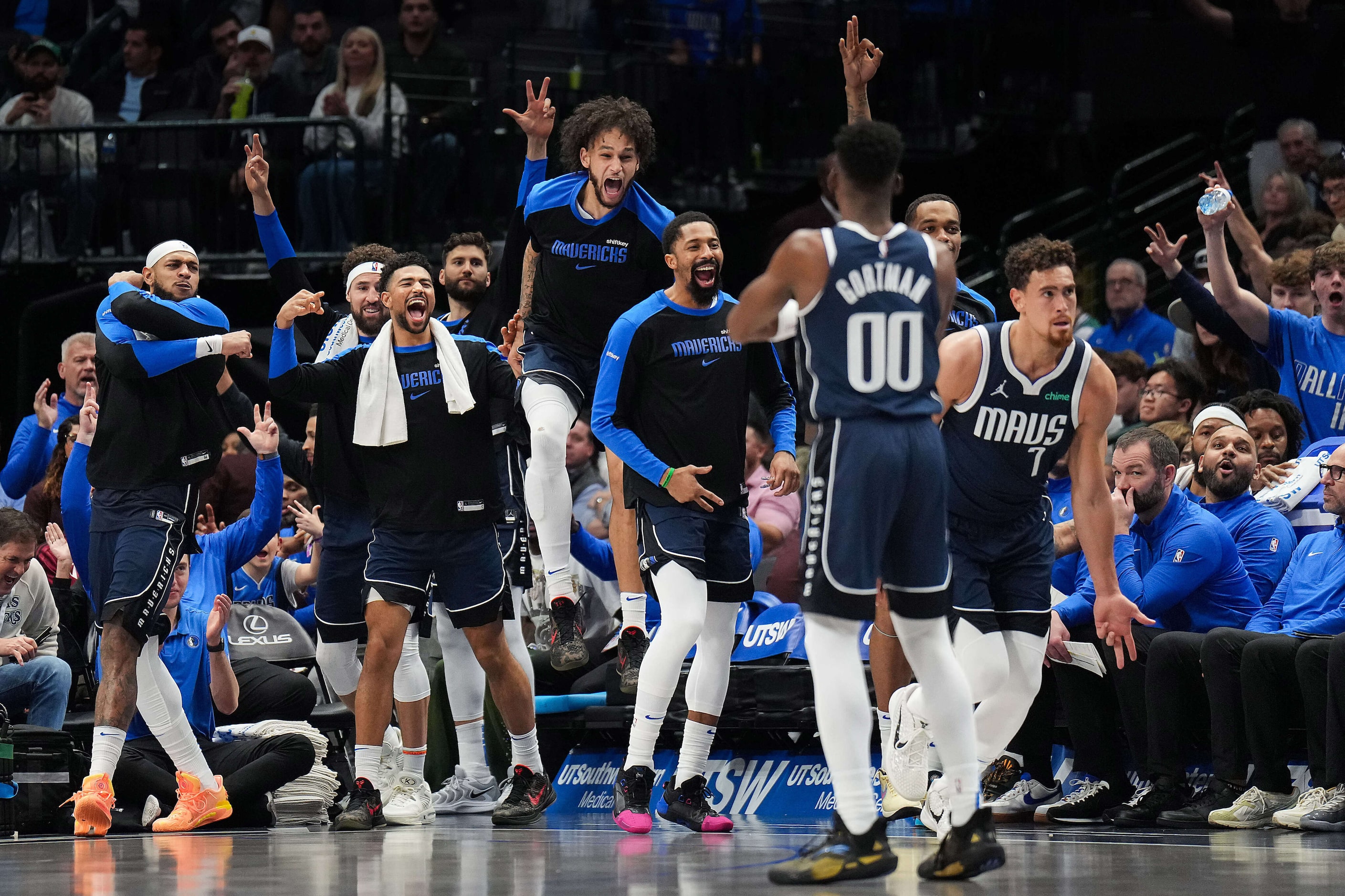 Dallas Mavericks center Dereck Lively II leaps in celebration with the rest of the bench...