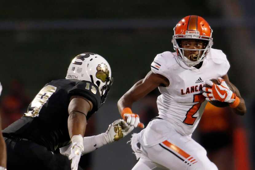 Lancaster back Tre Bradford (2) lunges out of the Tigers backfield as South Oak Cliff...