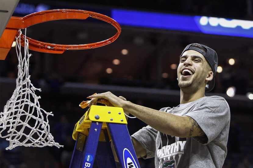 Florida's Scottie Wilbekin helps cut down the net after a 62-52 victory against Dayton in...