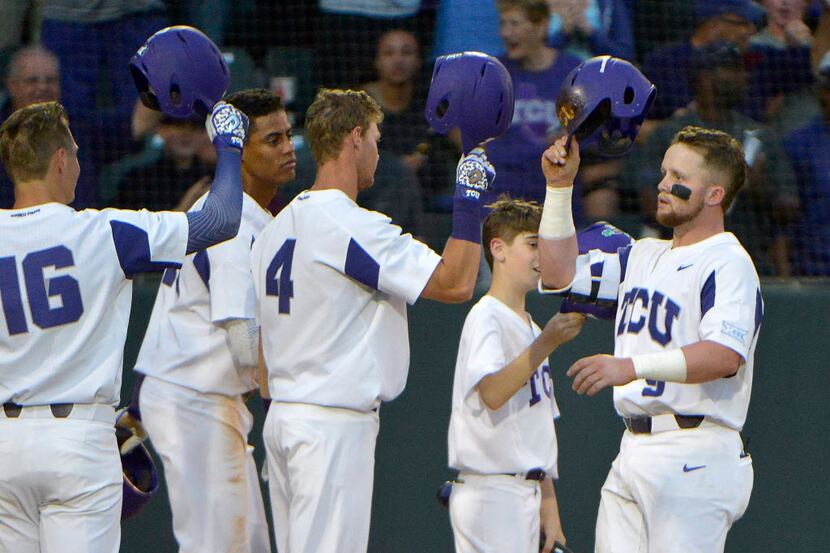 TCU catcher Evan Skoug (9), right, is congratulated by his teammates after hitting a grand...