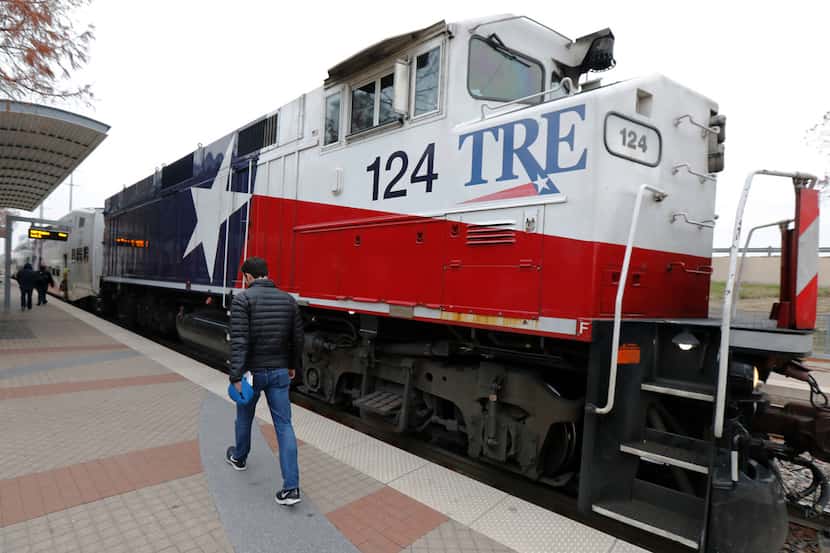 A Dallas Morning News reporter walks to board the Trinity Railway Express at Union station...