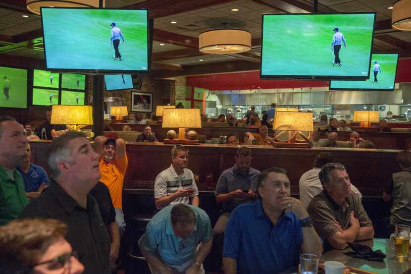  Fans at Champps Kitchen + Bar in Irving react as Jordan Spieth bogeys the 17th hole Monday,...