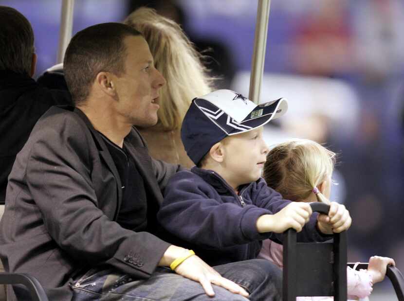 Lance Armstrong and his kids gets a ride off the field after the halftime show of NFL...