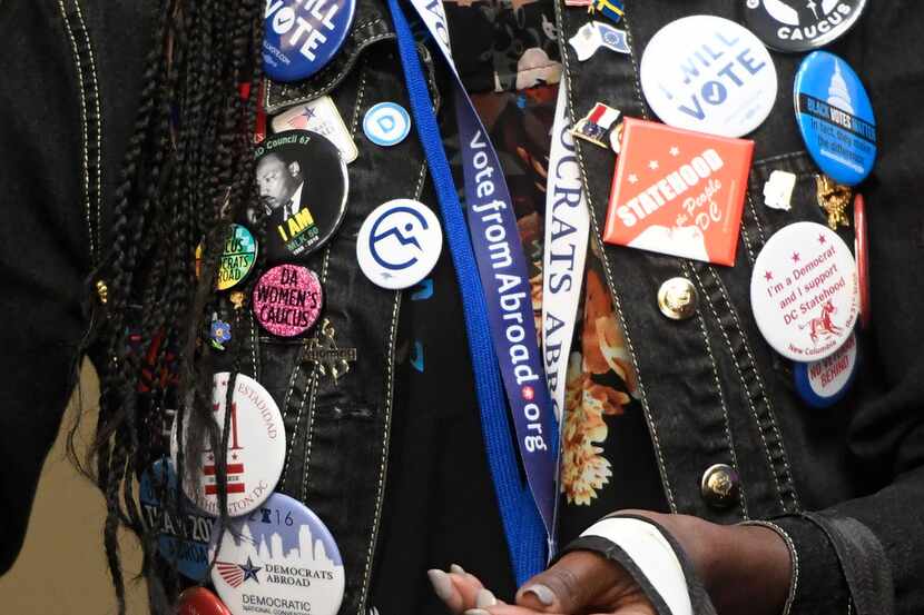 Adrianne George of Democrats Abroad wears pins at the Democratic National Committee's summer...