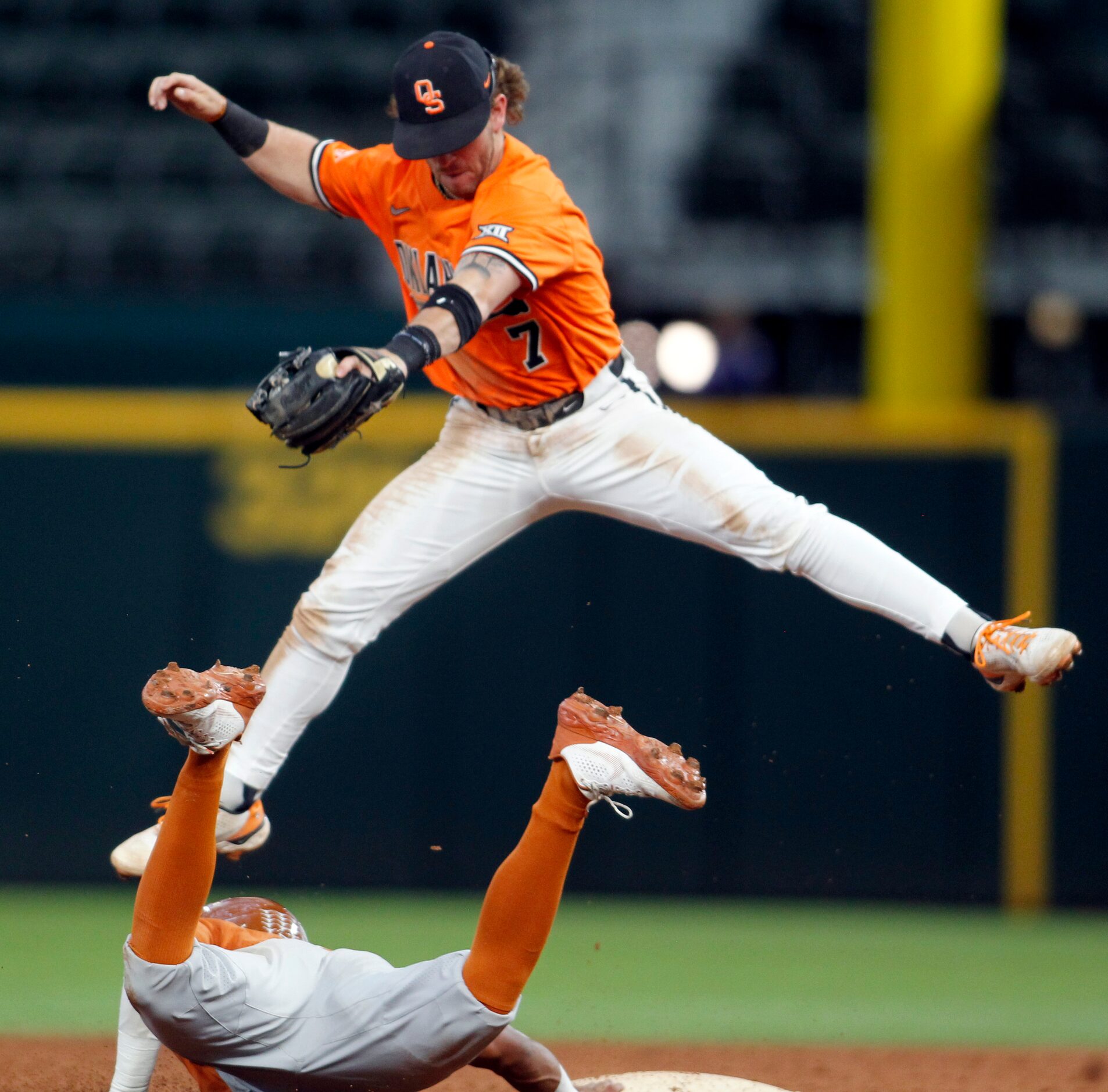 Oklahoma State 2nd baseman Roc Riggio (7) skies to pull down a high throw as Texas shortstop...