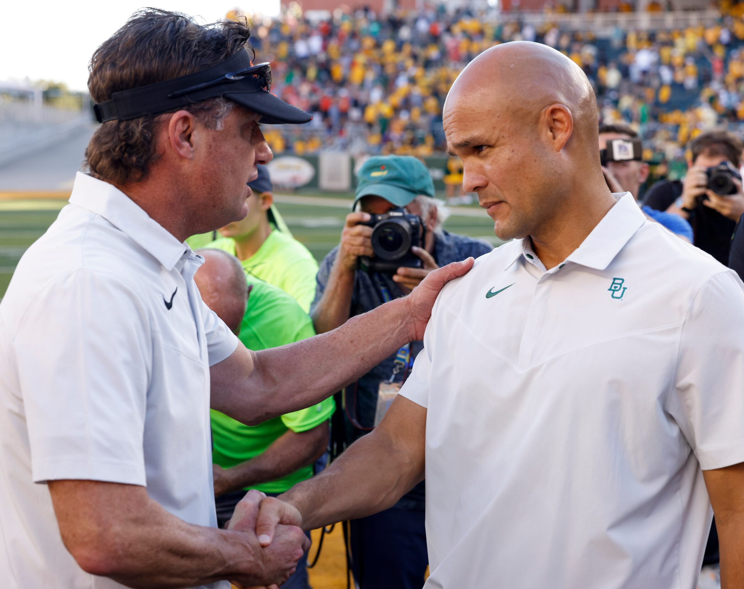 Oklahoma State head coach Mike Gundy (left) shakes hands with Baylor head coach Dave Aranda...