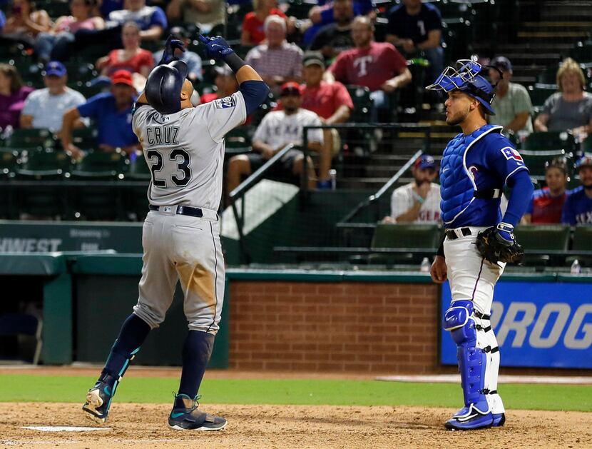 Seattle Mariners' Nelson Cruz (23) points skyward in front of Texas Rangers catcher A.J....